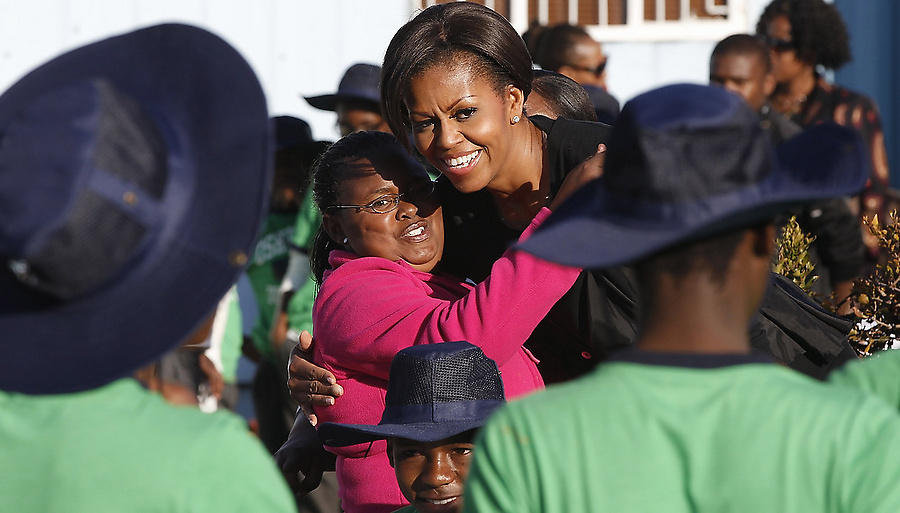 Michelle Obama embraces a girl with Love