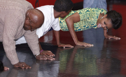 Michelle Obama does pushups with Desmond Tutu