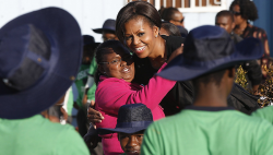 Michelle Obama embraces a girl with Love