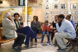 Michelle Obama, her daughters and some South African youths listen attentively to a Historian