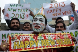 Indian revellers hold placards in Amritsar saying 'happy New Year'.jpg