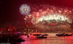 Spectator boats in Sydney Harbour look on as the New Year's Eve fireworks erupt over the Sydney